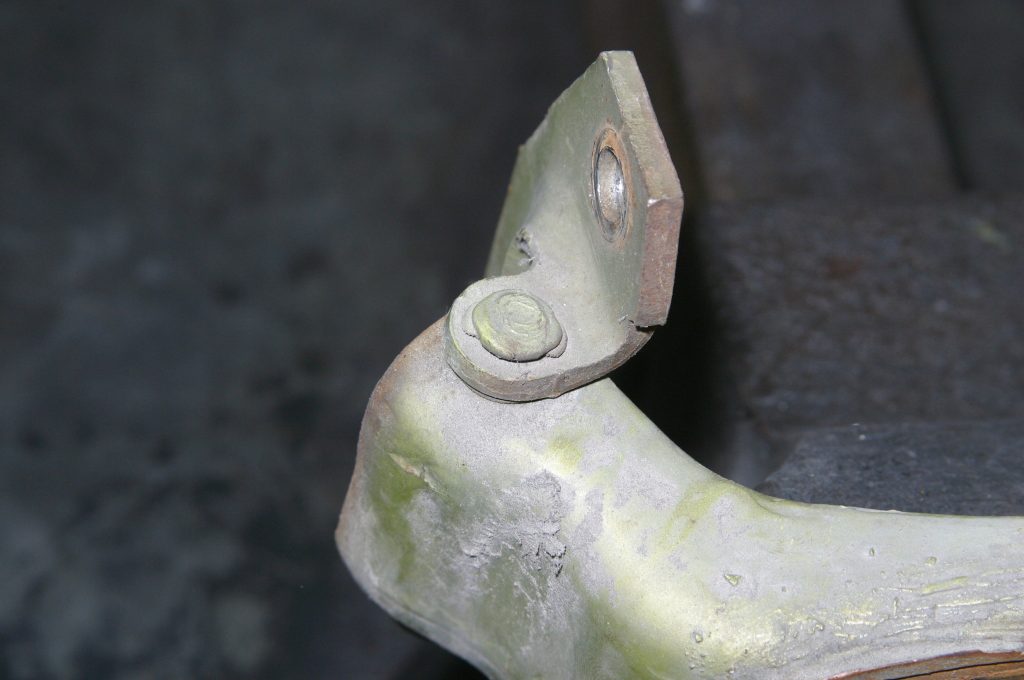 close up of hinge pin top on a car door bracket