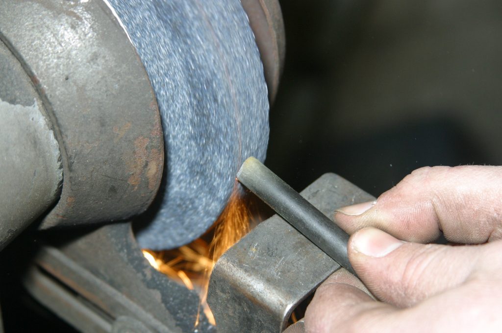 grinding the tip of a car door hinge pin