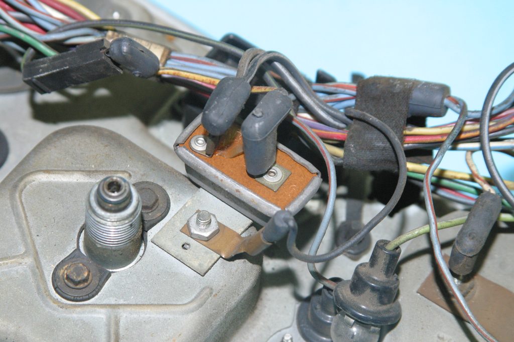 close up of plugs behind a vintage vehicle gauge cluster