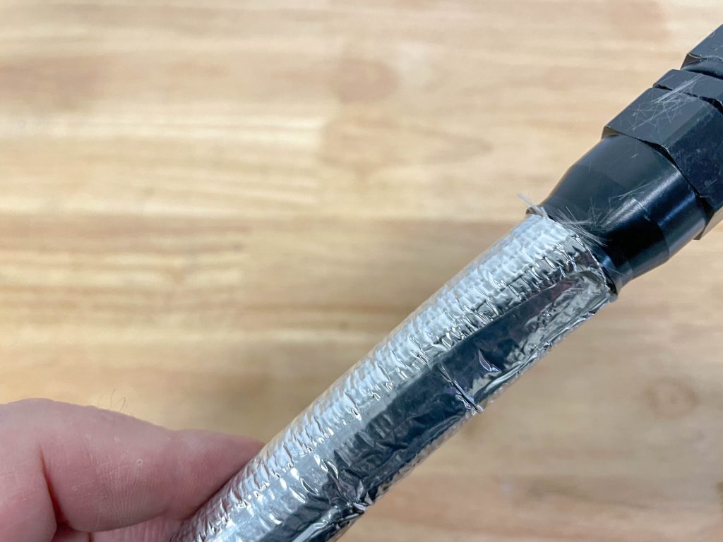 an automotive plumbing hose wrapped in a heat shield