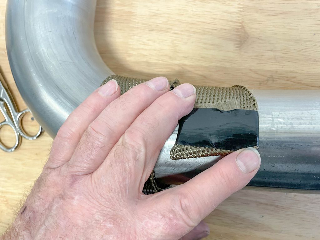 starting a heat shield wrap around an exhaust header tube