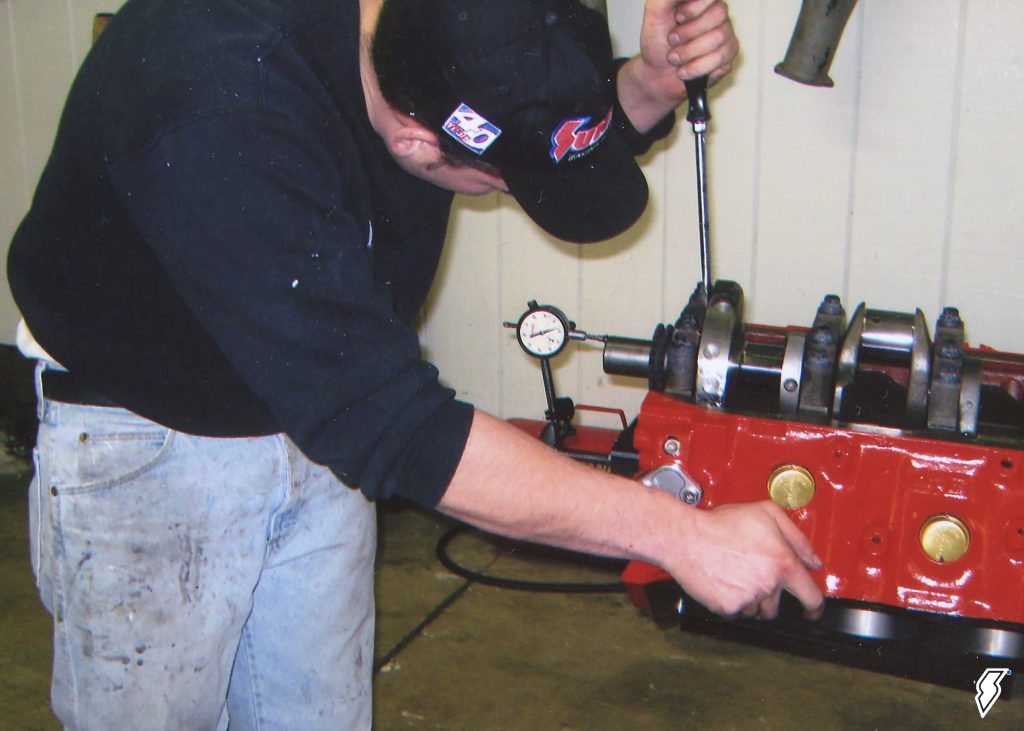 man checking crank endplay in a race engine block