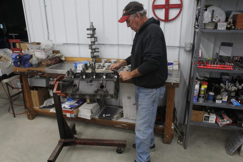 man assembling a bare engine block