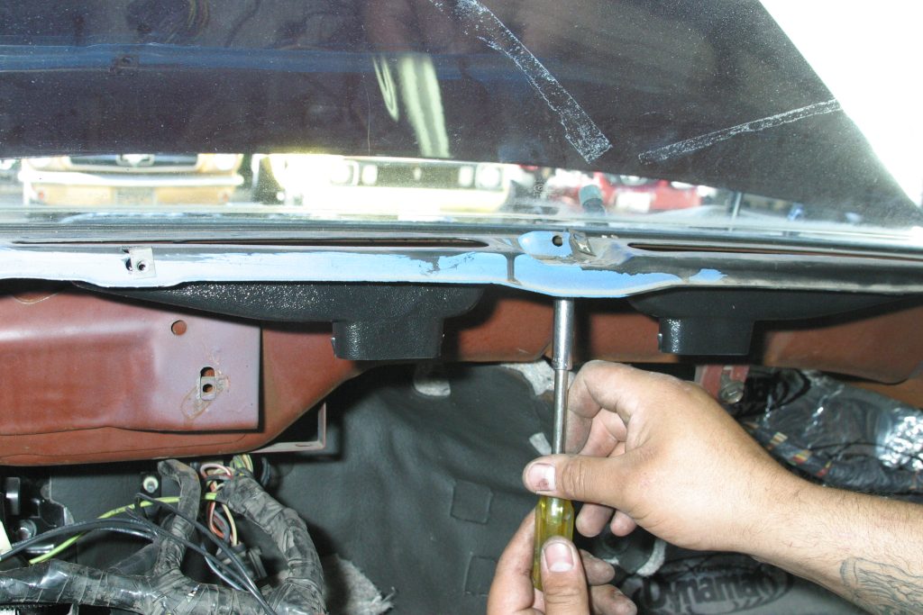 man removing screw from a vintage ford mustang dash