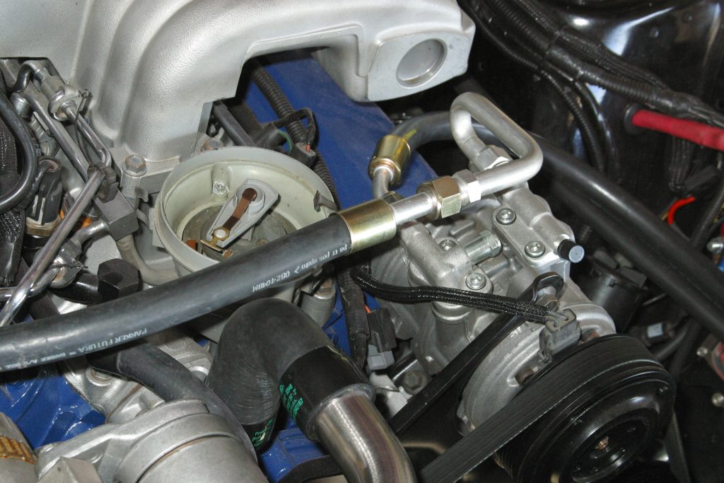 a modern air conditioning compressor on a vintage mustang engine