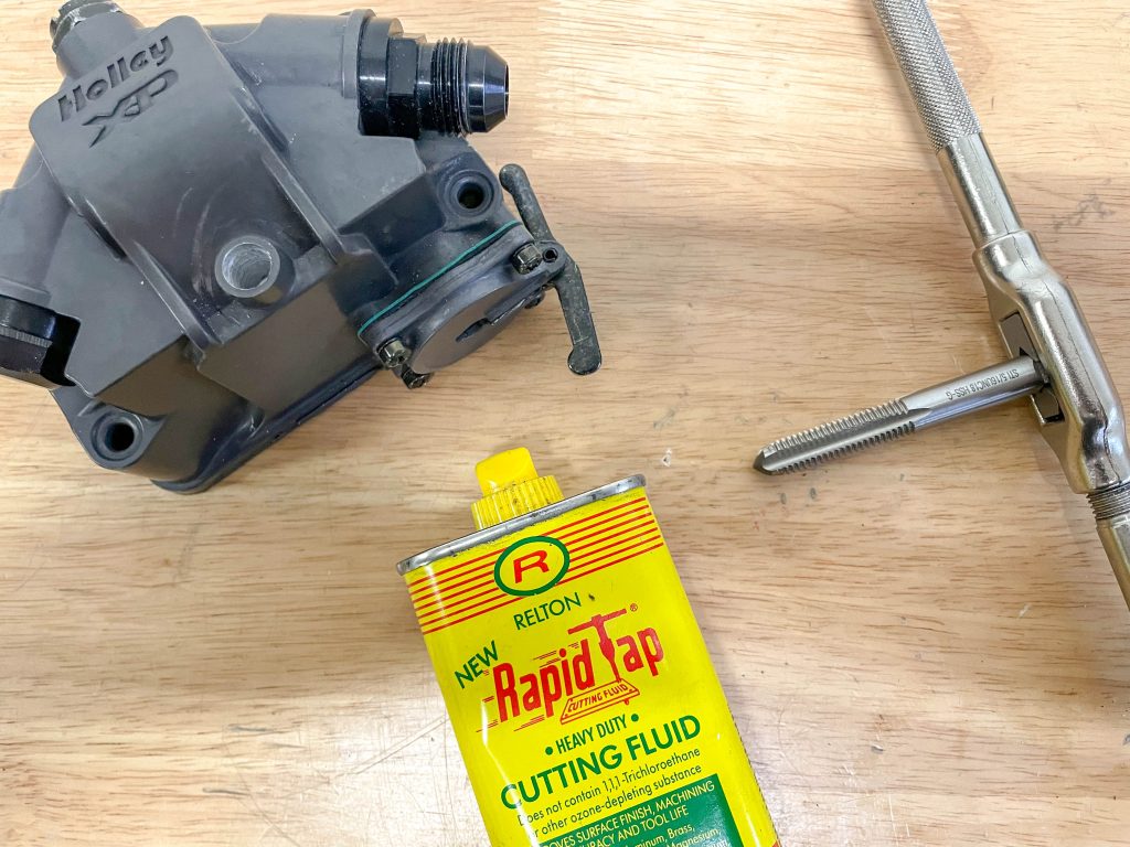 thread tap and cutting fluid on a workbench