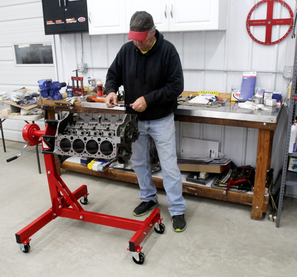 man assembling an engine on a stand