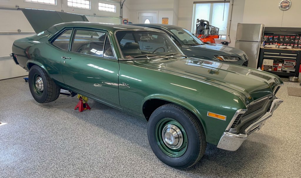 vintage chevy nova on jack stands in a garage