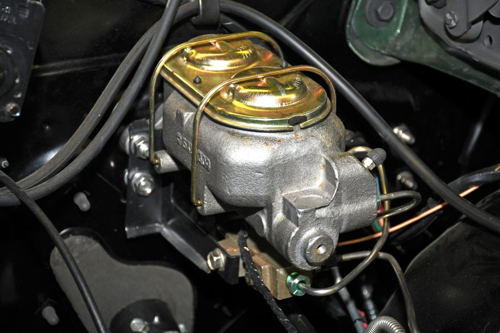 A cast iron brake master cylinder in a vintage car