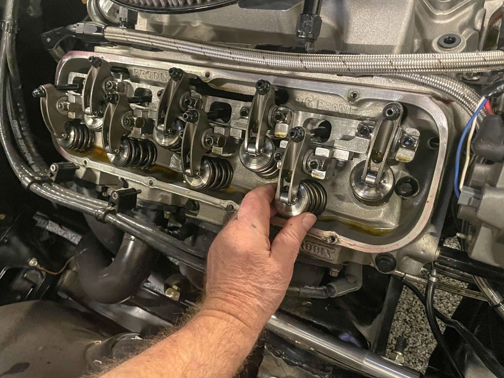 man checking valve spring on a engine cylinder head