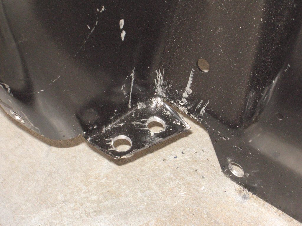 holes drilled in a mustang shock mount fender tab