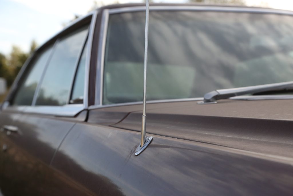 close up of a telescopic radio antenna on an old car
