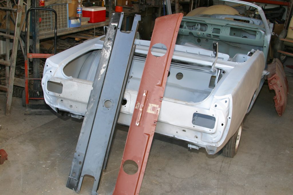 a pair of replacement panels leaning against a vintage mustang