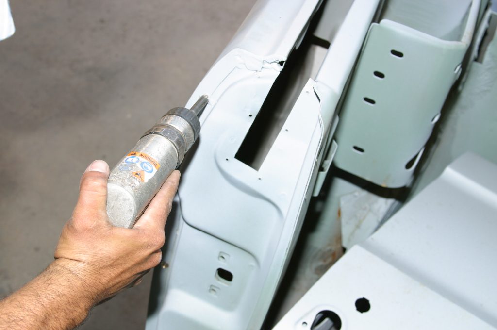 using a spot weld remover tool on a car body