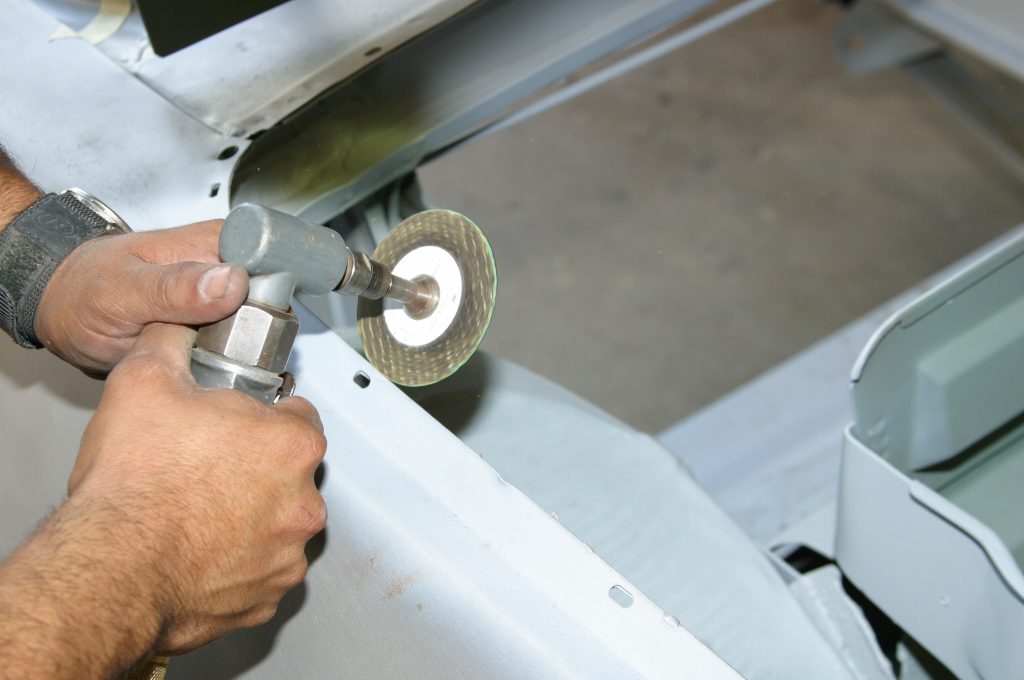 using a disc cutting tool on a vintage car body