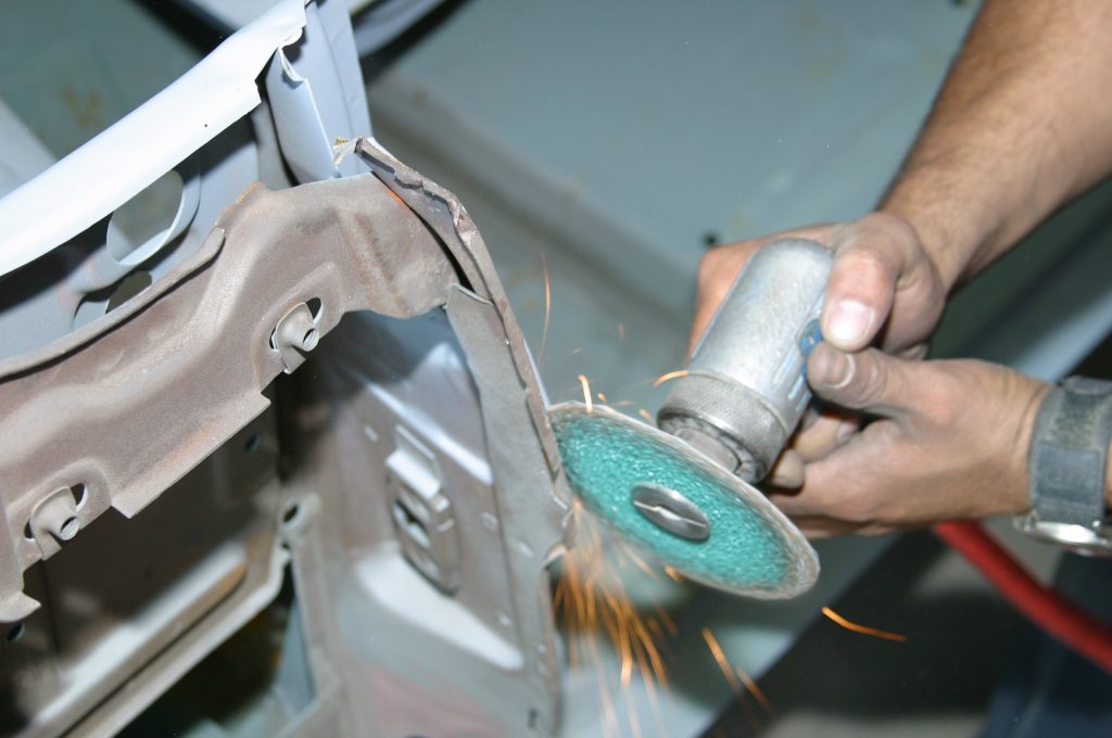 using a disc grinder cutting tool on a car body