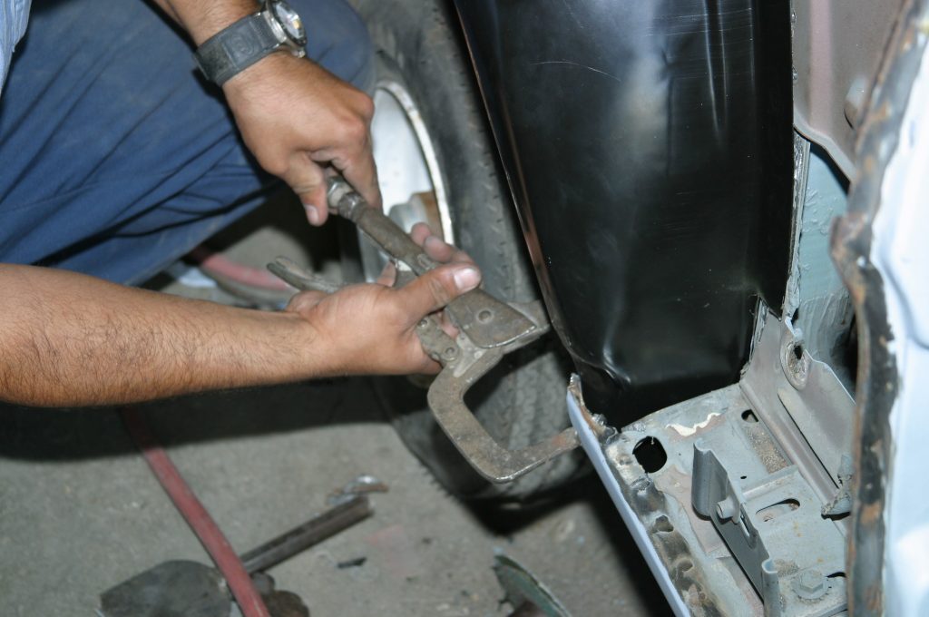 man clamping fender prior to welding