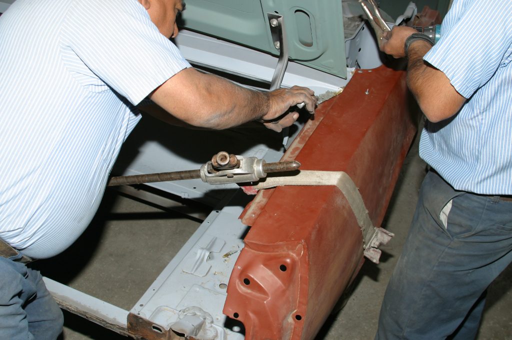 a replacement quarter panel getting clamped into a car
