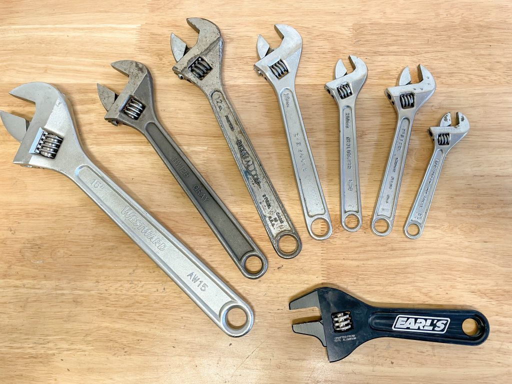 assortment of adjustable wrenches on a workbench