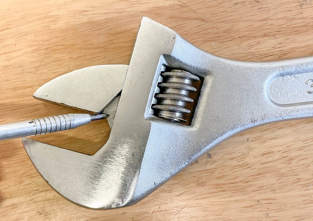 pointing to the jaws of an adjustable wrench