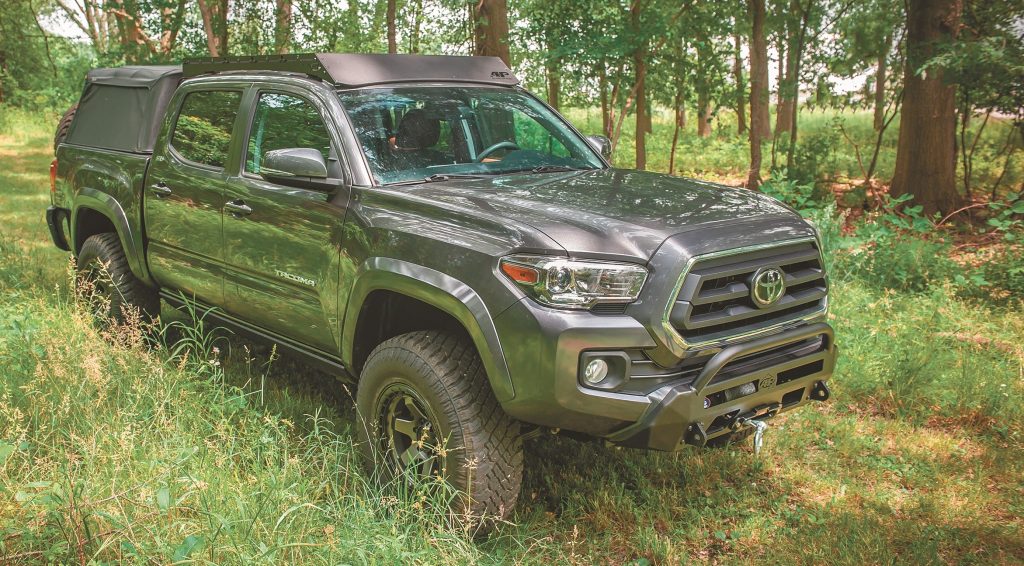 off road toyota tacoma driving through wooded trail