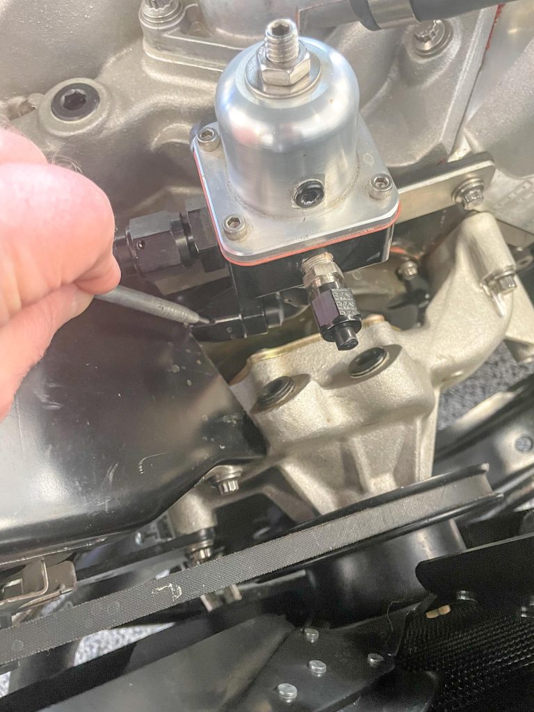 inserting a fitting into a fuel pressure regulator