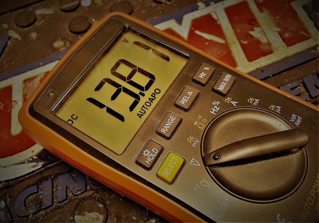 stylized photo of a digital multimeter displaying 13 volts dc