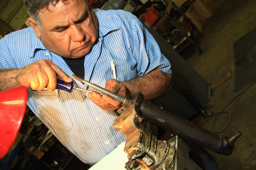 man rebuilding a power steering cylinder