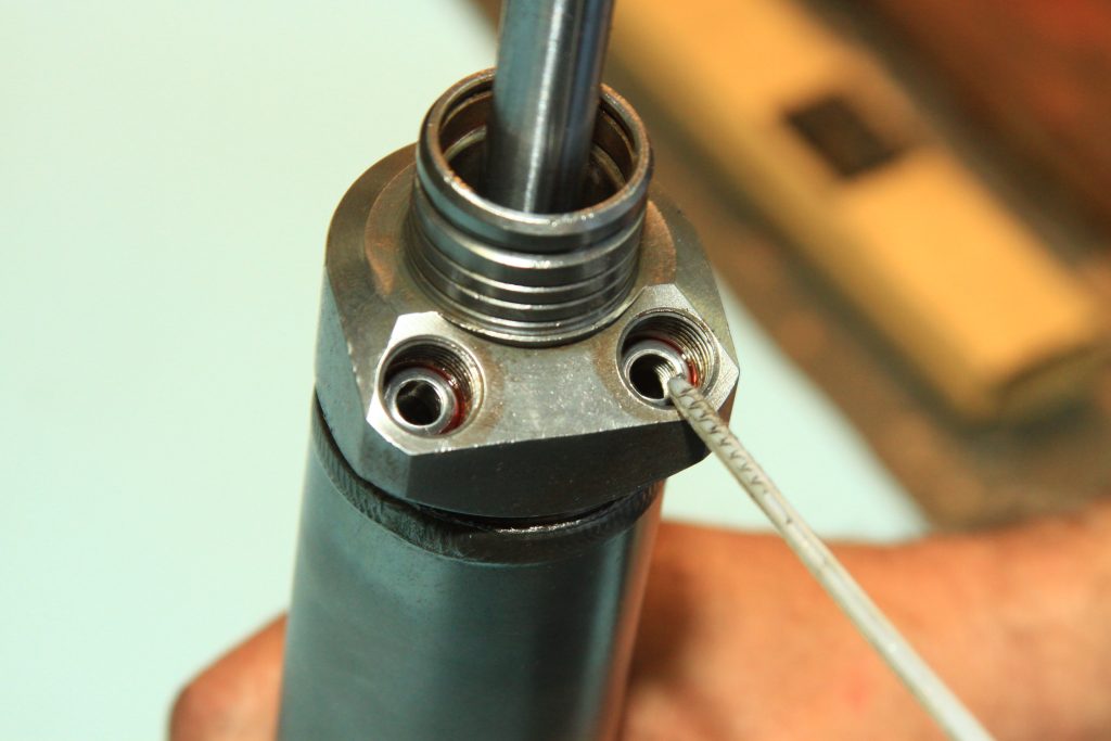 pointing to a threaded shaft in a hydraulic cylinder