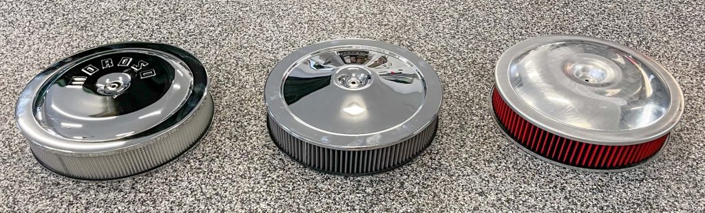 3 air cleaners arranged on a garage floor