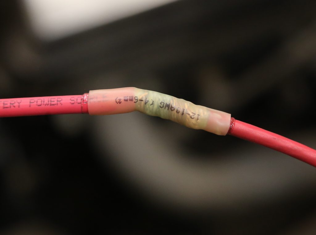 a wrapped wire splice in shrink tubing