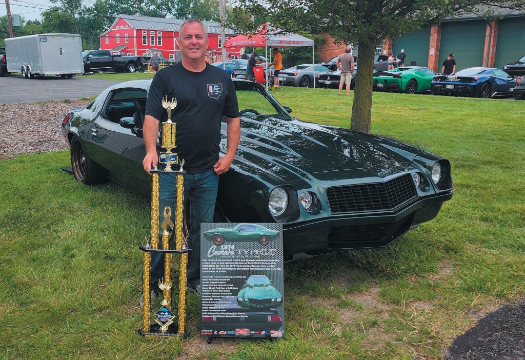 man with car trophy at a show
