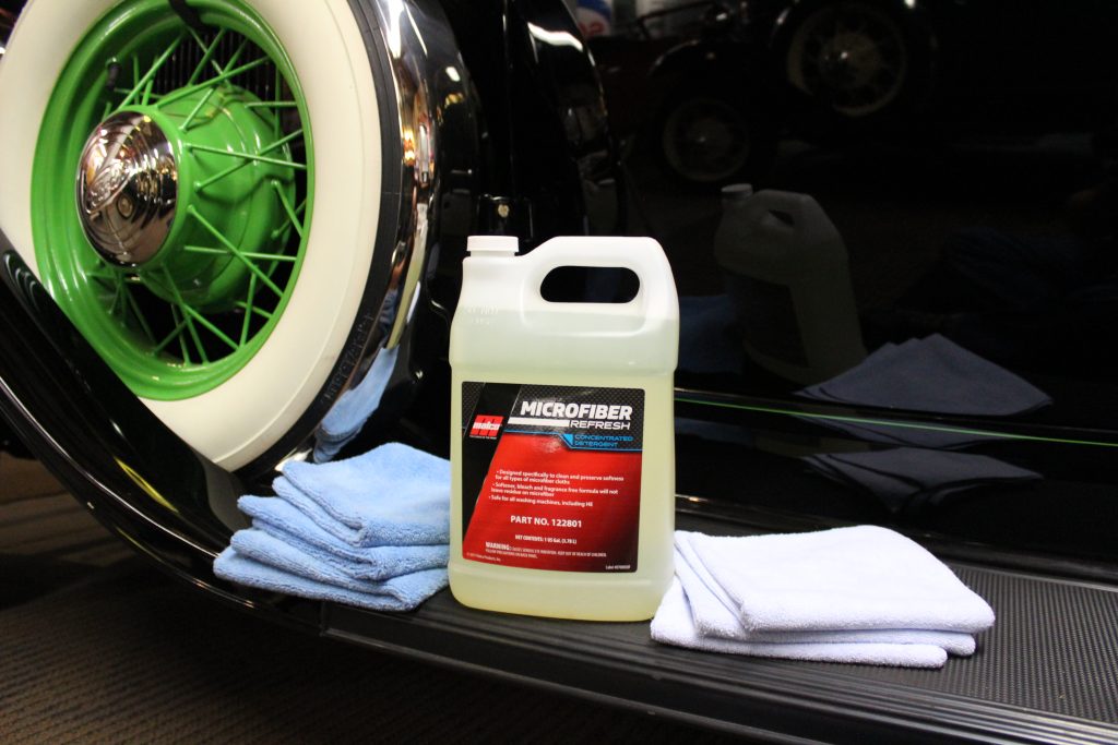 microfiber towels and cleaner on fender of an old car