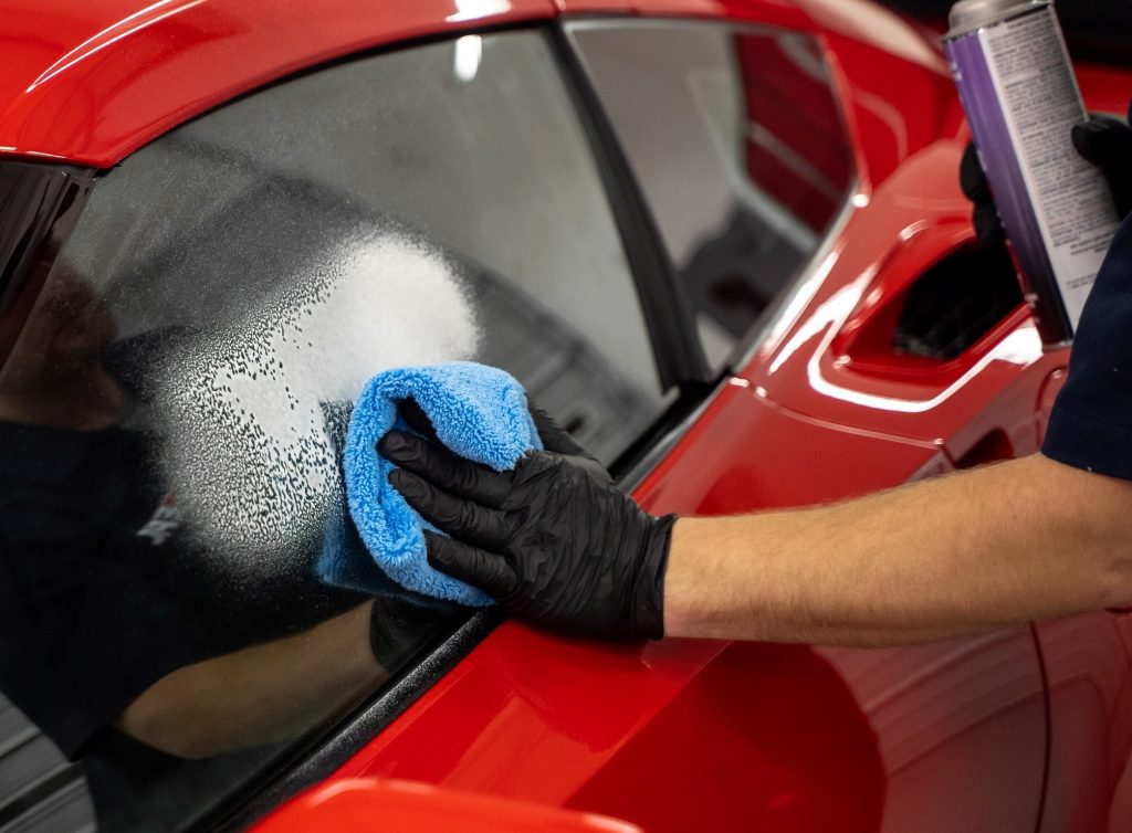 man wiping a window clean with a microfiber towel