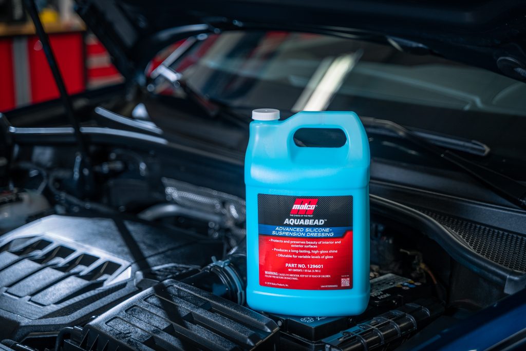 jug of car sealer wash resting near an engine