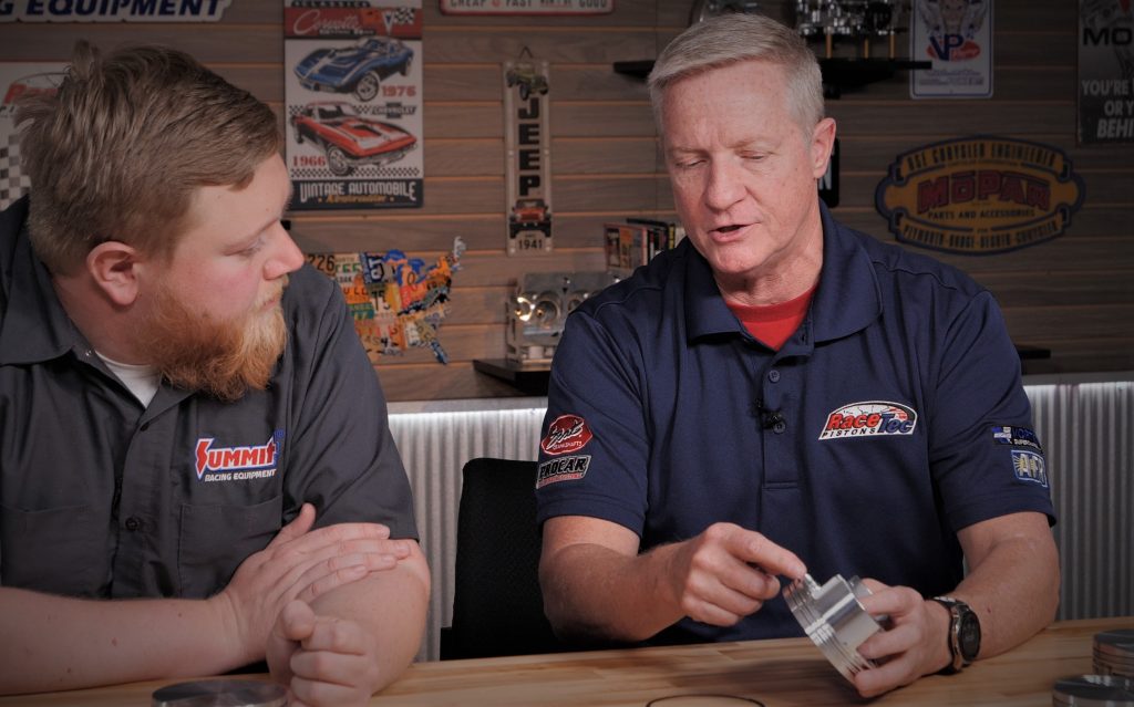 two men at a table with pistons