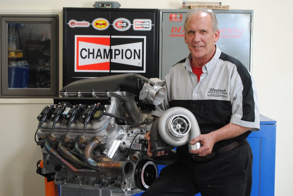 man holding a turbo near an engine