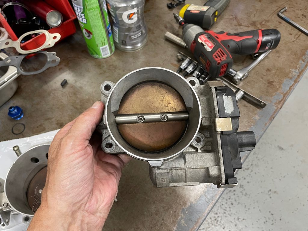 man holding throttle body for an ls engine