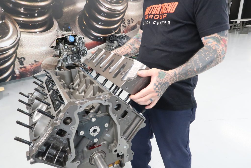 man fitting cylinder head onto an engine
