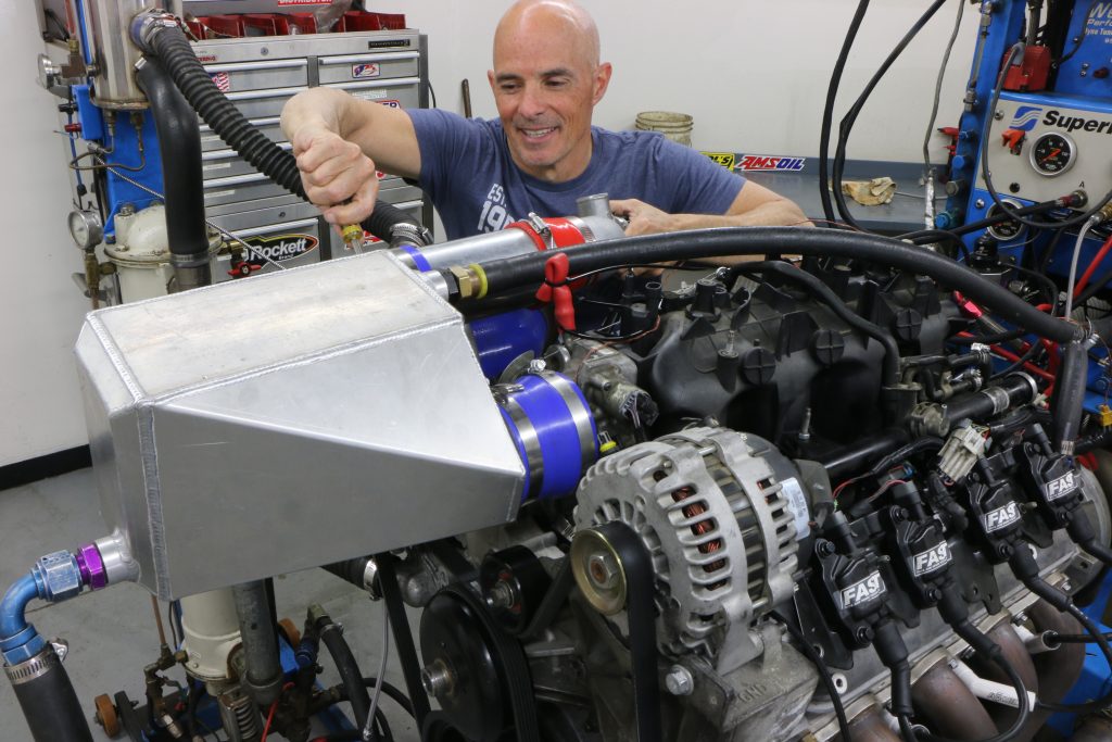 man installing an air-to-water intercooler on dyno