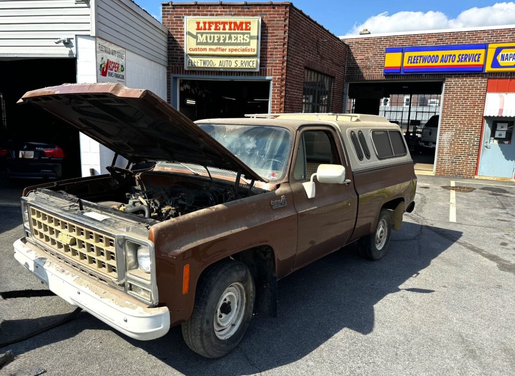 old Squarebody Chevy truck in front og a mechanic shop