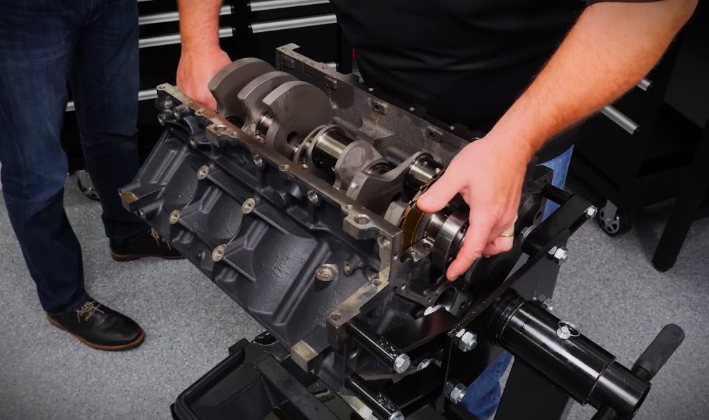 man dropping crankshaft into an engine block