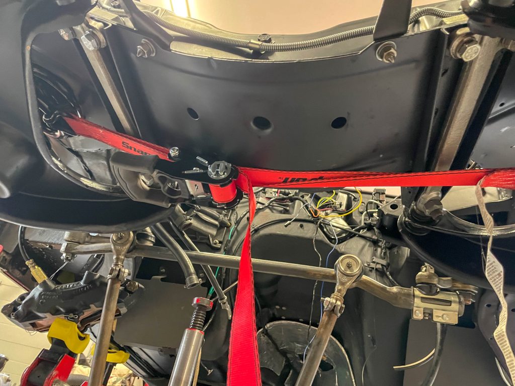 Coil springs tied together with ratchet strap during ball joint separating