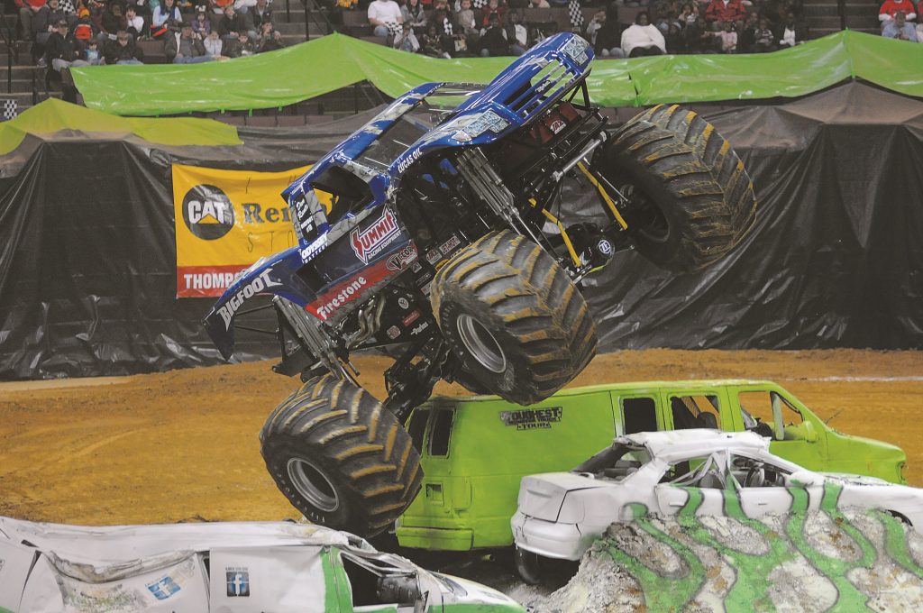bigfoot monster truck flying over crushed cars in arena