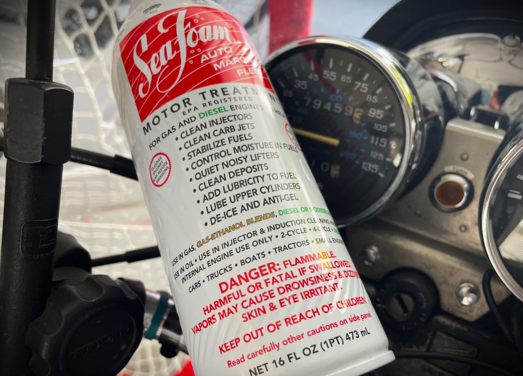 seafoam can resting on a motorcycle handlebars