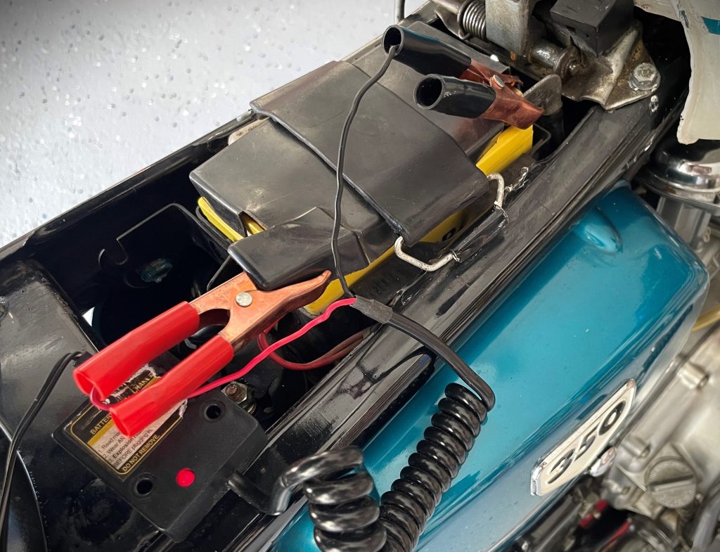 vintage motorcycle hooked up to a trickle charger