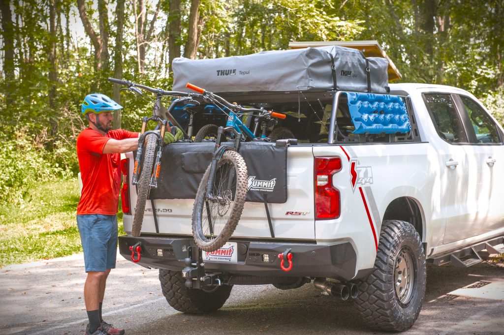 man loading bicycle into a chevy silverado