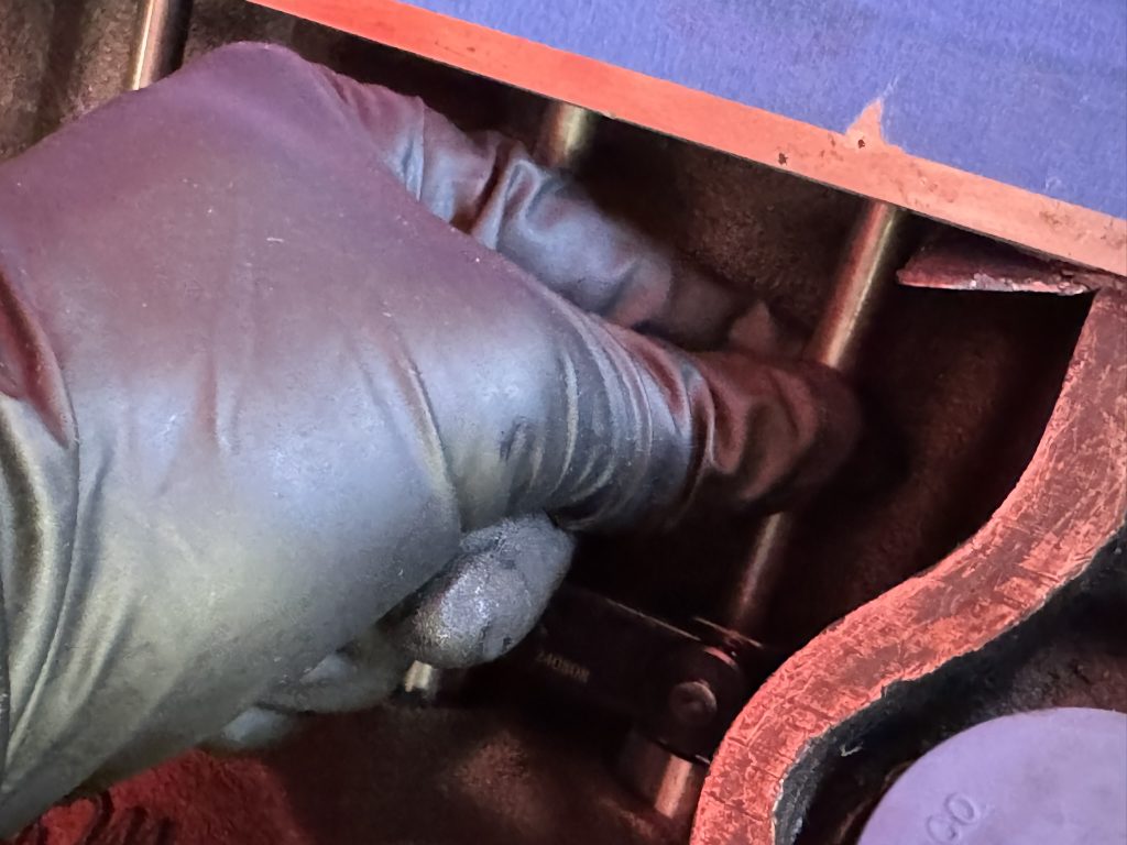 man grabbing pushrod in an engine