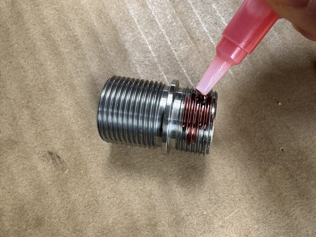 applying threadlocker to barrel plumbing fitting