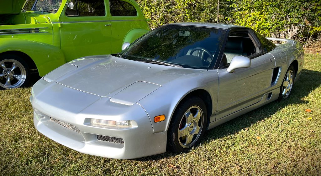Silver Acura NSX parked on grass